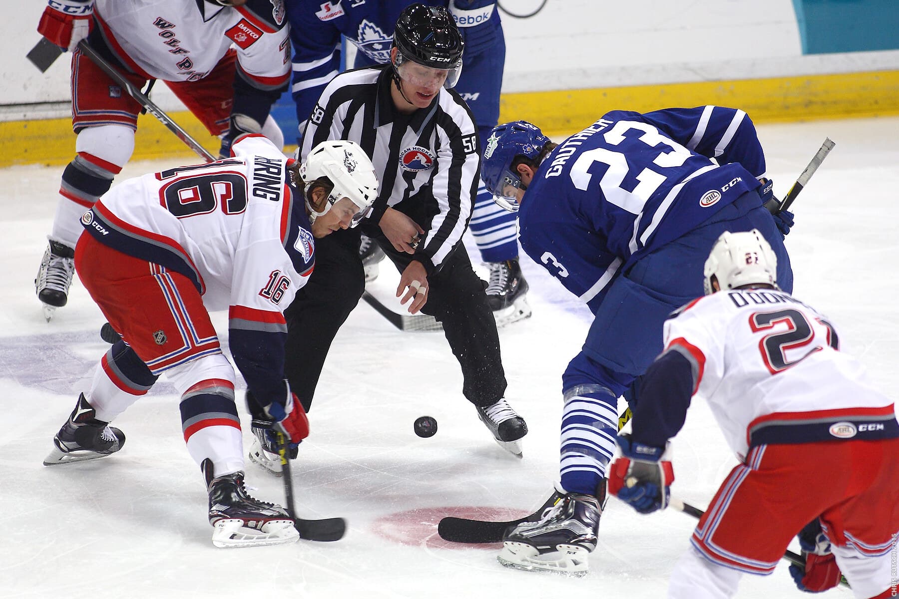 Hockey players in custom team jerseys at a face-off